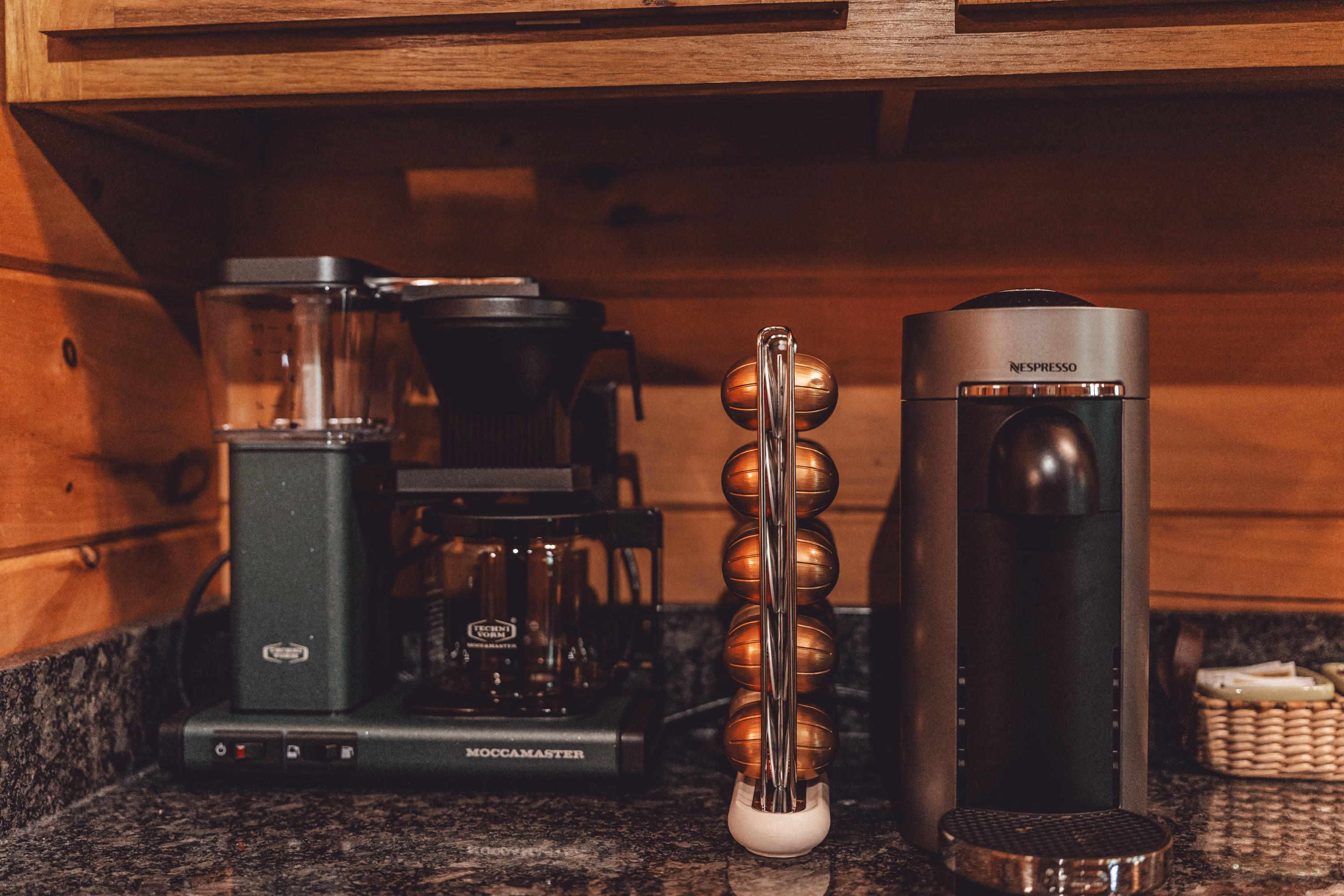 A coffee maker and pod machine on the granite counter