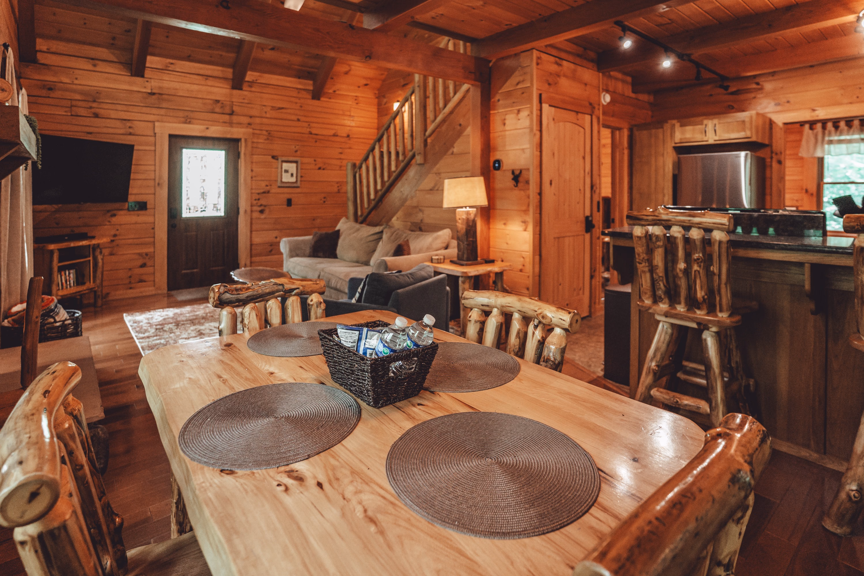 The log dining table and island with the living room beyond