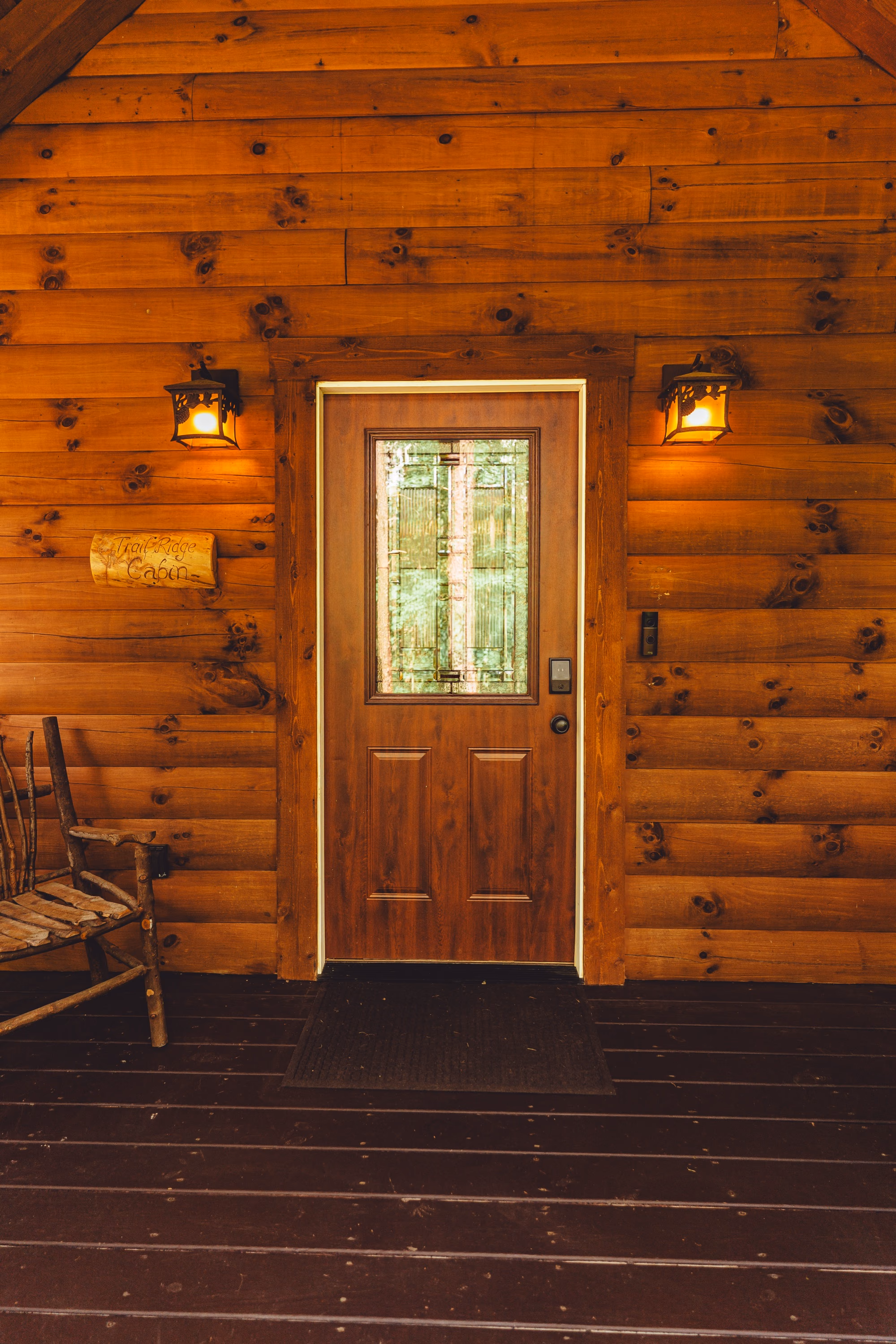 The front door at dusk, lit by a lantern on either side