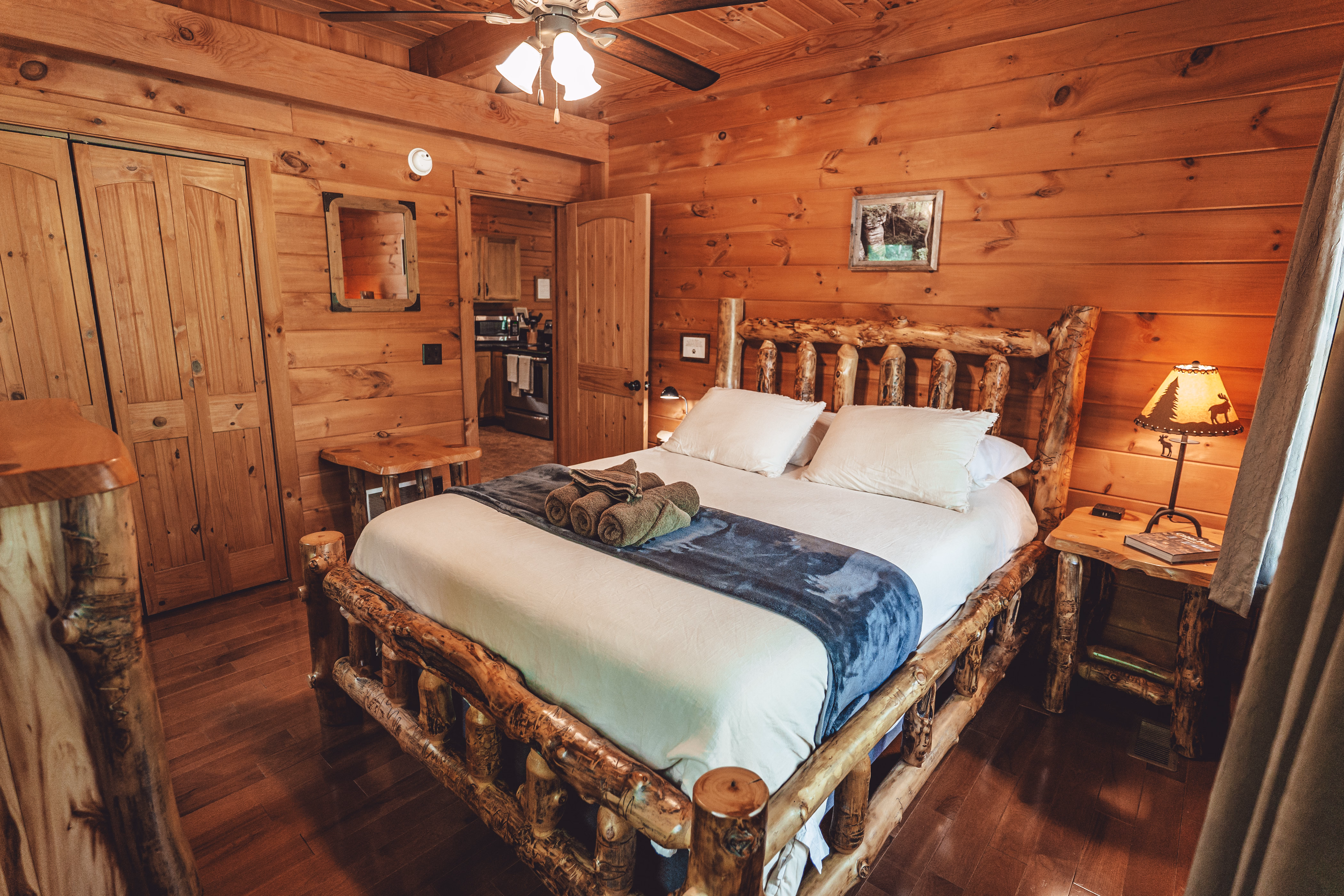 Bedroom with a queen bed, log furniture, and warm timber walls