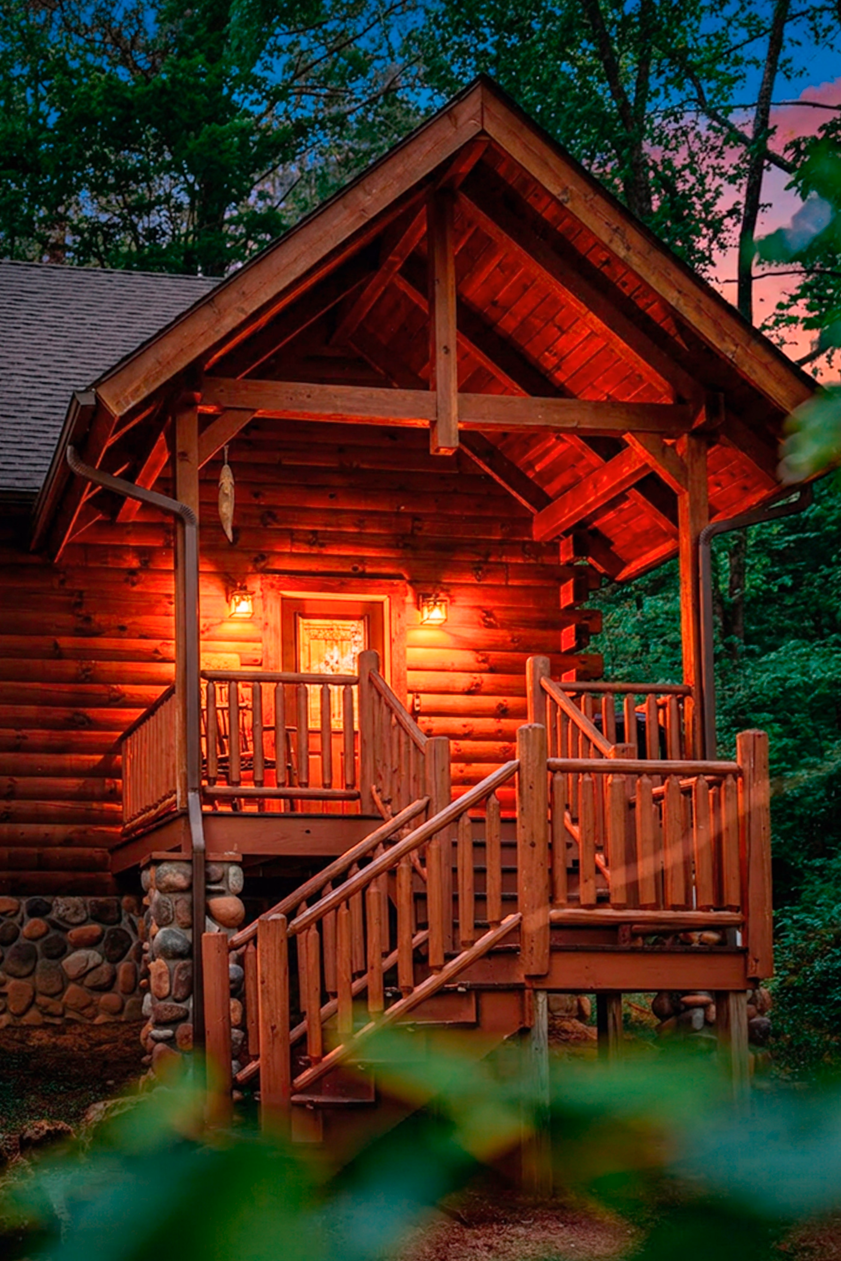 The cabin’s front porch glowing warmly at twilight