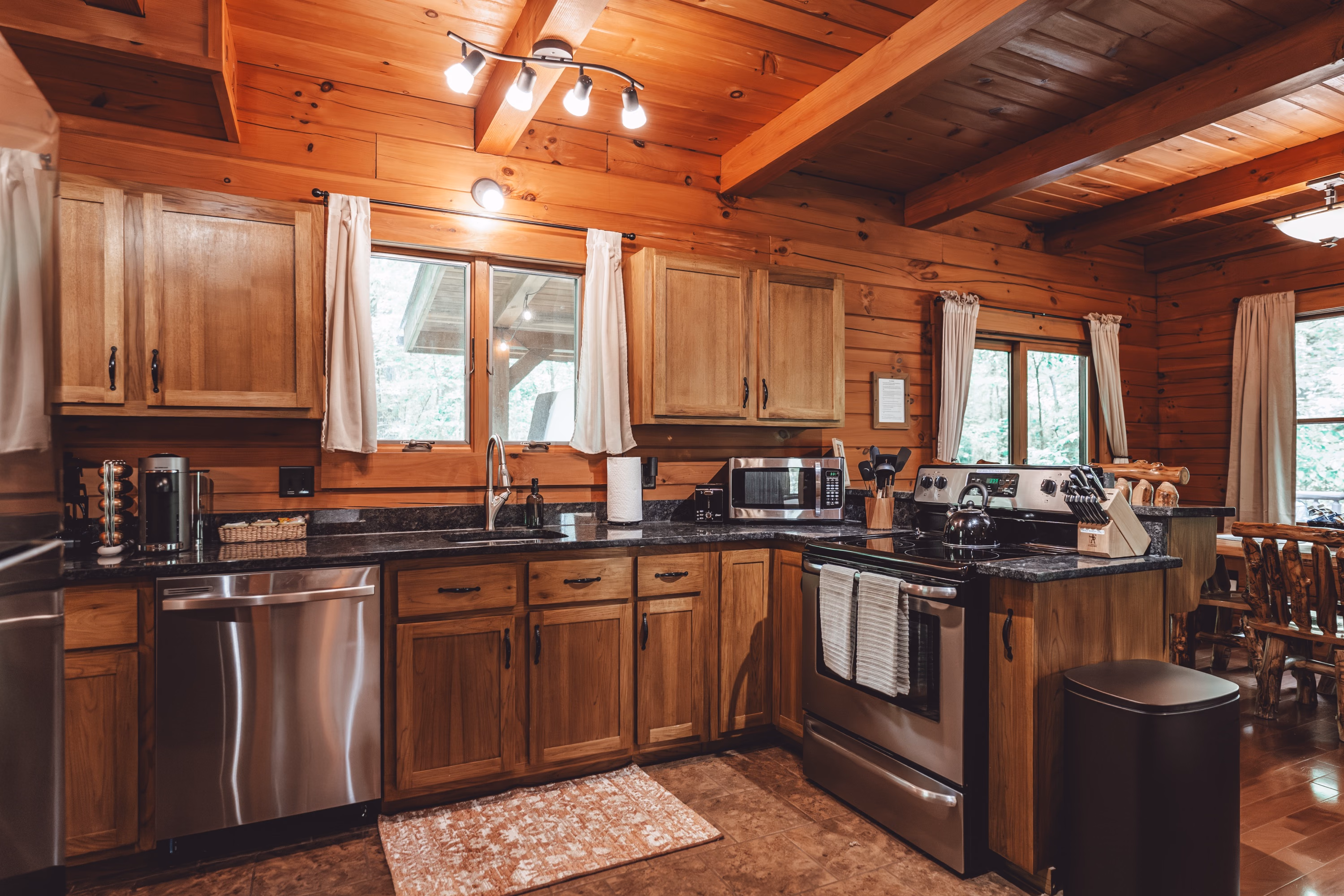 The kitchen with wood cabinets, stainless appliances, and a window over the sink